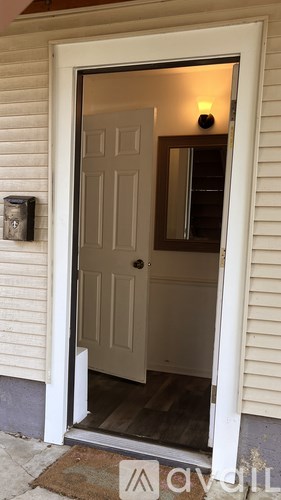 A white door with a glass window is open.