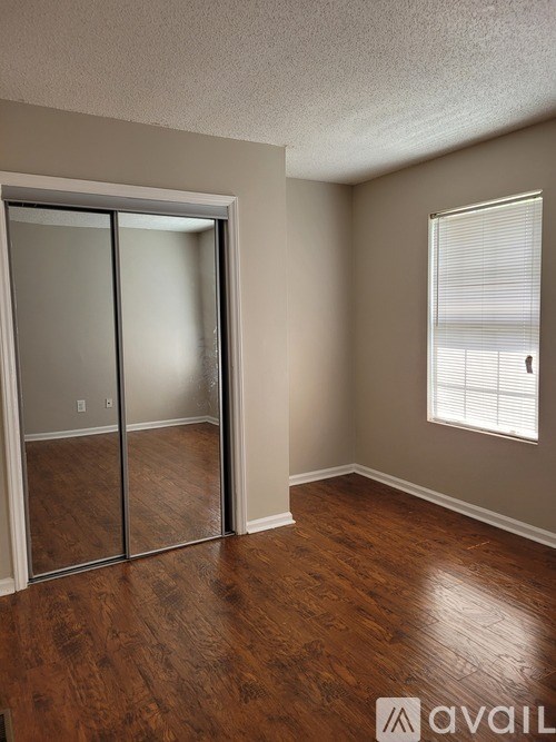 A room with a sliding glass door and wooden flooring.