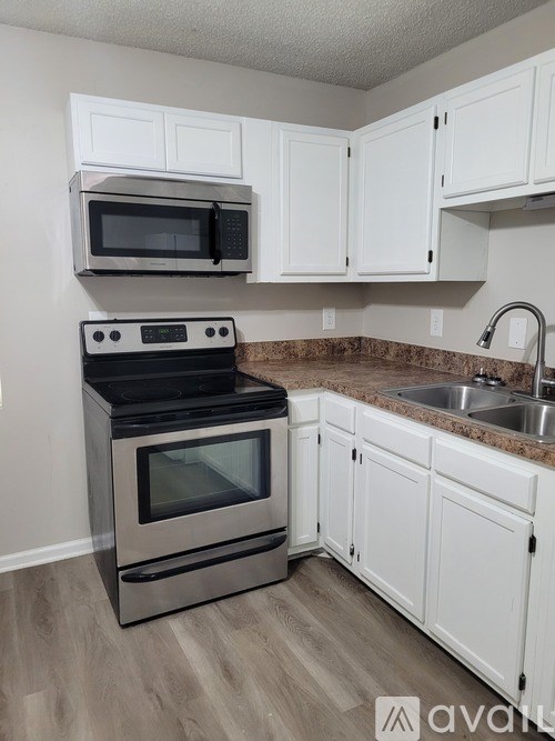 A kitchen with a stove, microwave, and cabinets.
