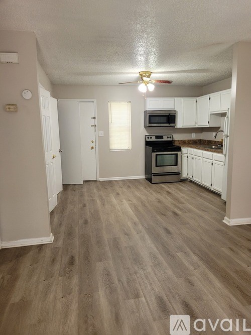 A kitchen with a black stove top oven and white cabinets.