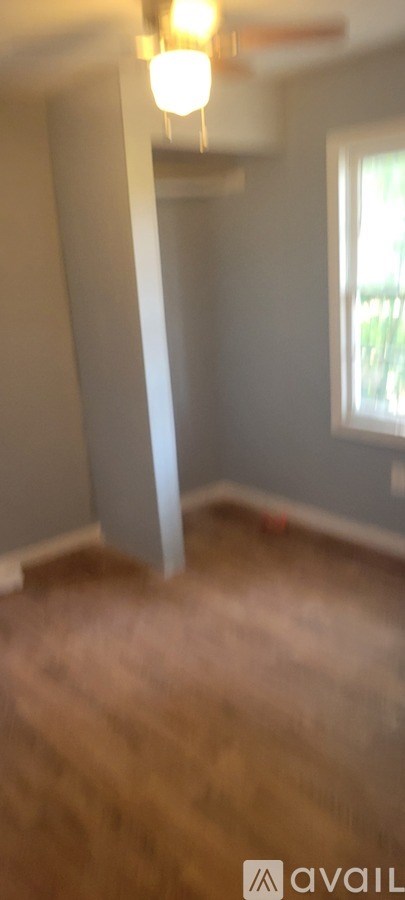 A room with a wooden floor and a window.