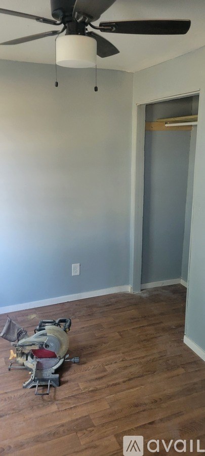 A room with a ceiling fan and a chair.