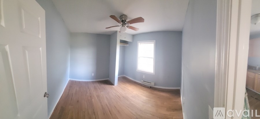 A room with a ceiling fan and a window.