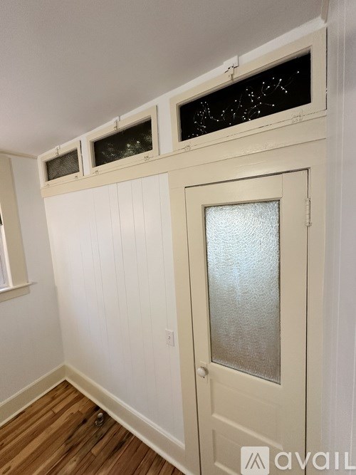 A white door with frosted glass panels above it.