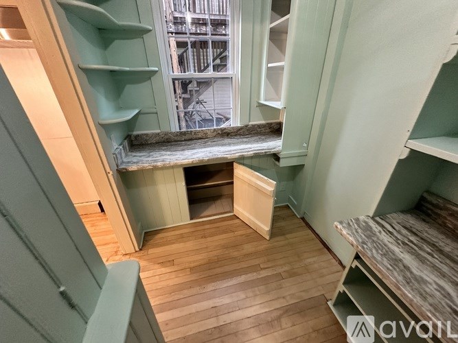 A wooden staircase with a green railing and a wooden floor.