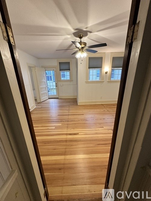 A room with wooden floors and a ceiling fan.