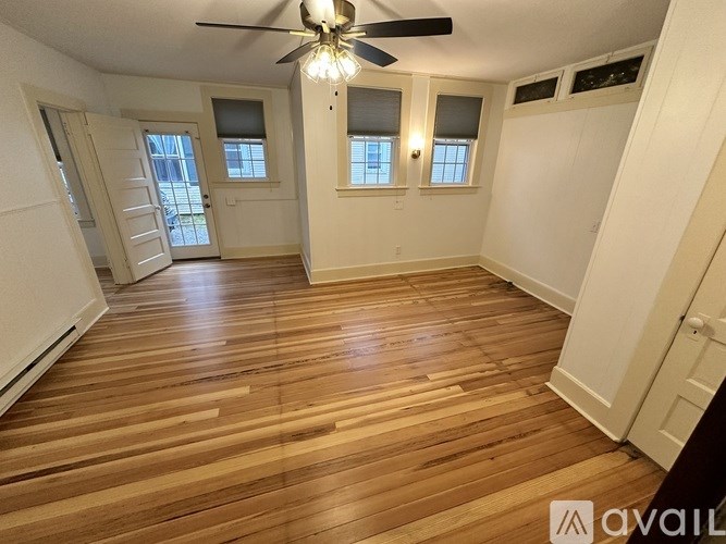 A room with wooden flooring and a ceiling fan.