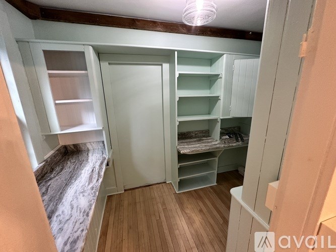 A room with a marble bench and wooden flooring.