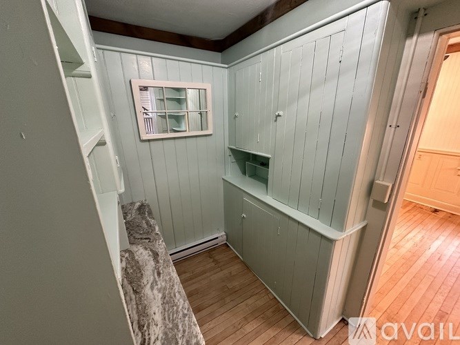 A room with wooden floors and a window with bars on it.