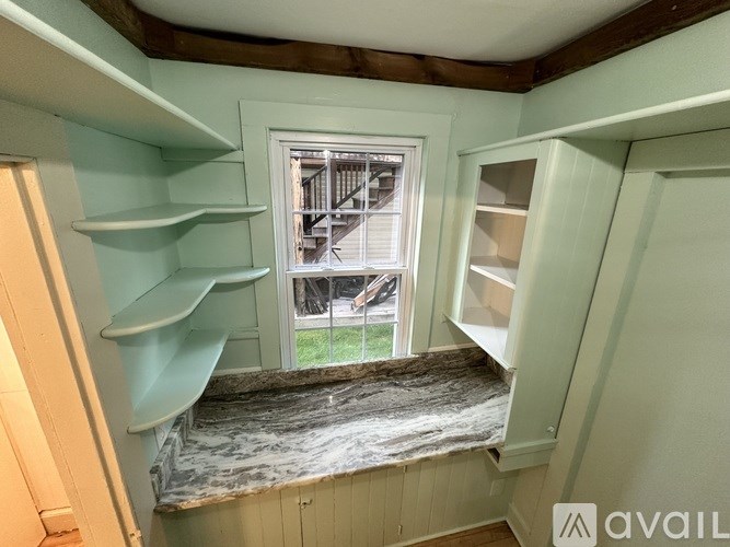 A room with a window and a view of a building outside.