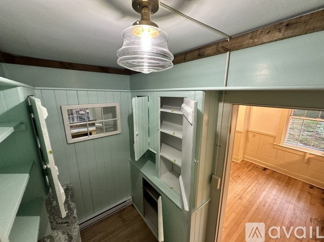 A kitchen with green cabinets and a wooden floor.