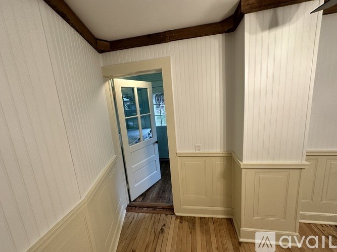 A room with white walls and a wooden floor.