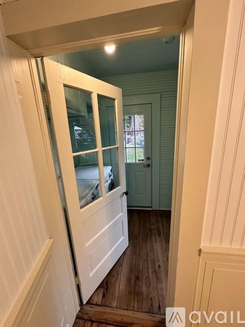 A white door with a glass window is open.