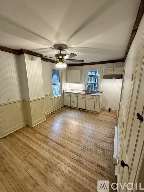 A room with wooden floors and a ceiling fan.
