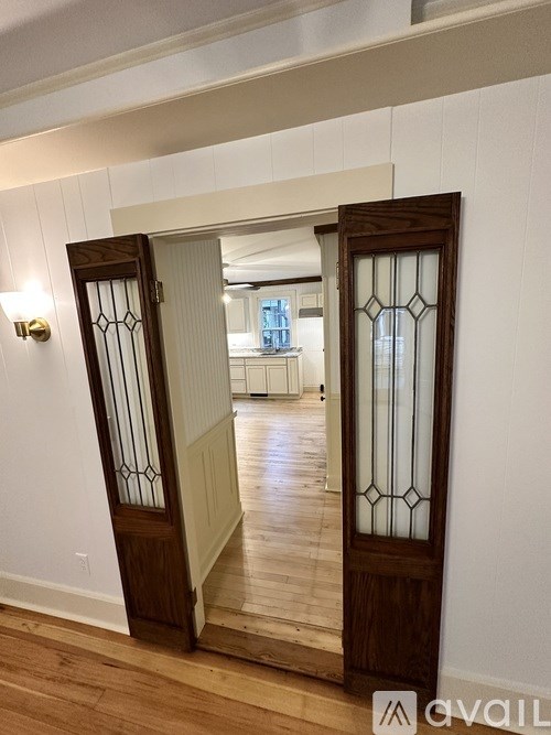 A pair of double doors with stained glass panels lead to a hallway.