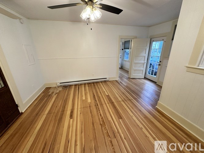 A room with wooden flooring and a ceiling fan.