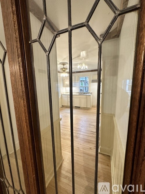 A hallway with a wooden floor and a stained glass window.