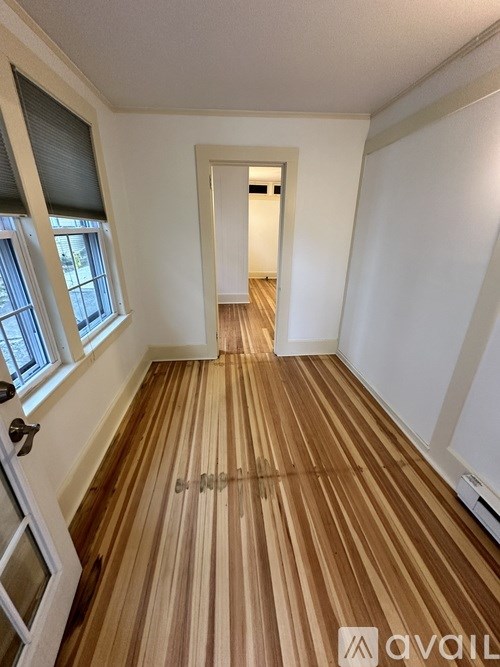 A room with wooden flooring and a white door.