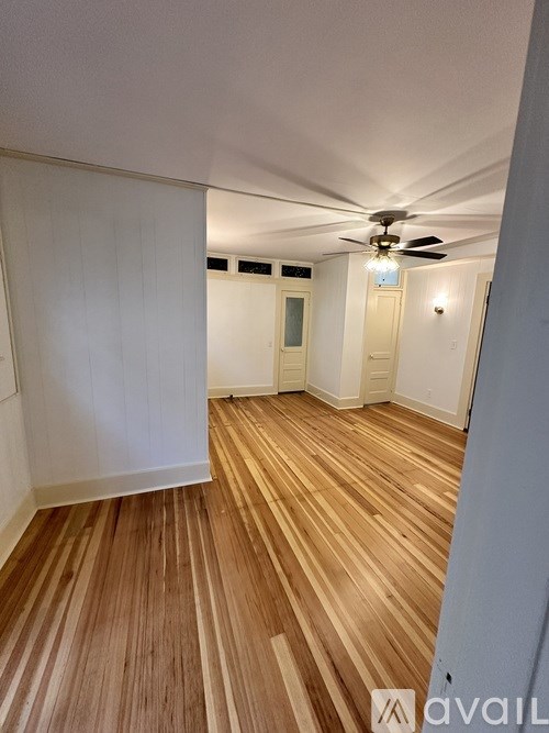 A room with wooden flooring and a ceiling fan.