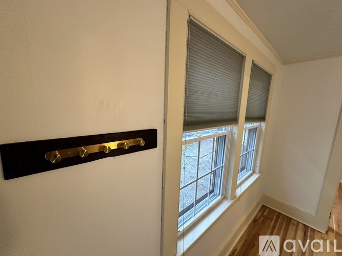 A room with a window and a black shelf with brass handles.