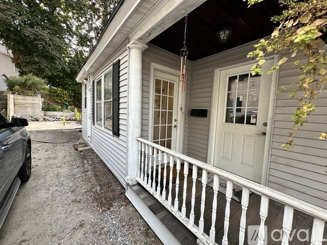 A small house with a white door and a porch.