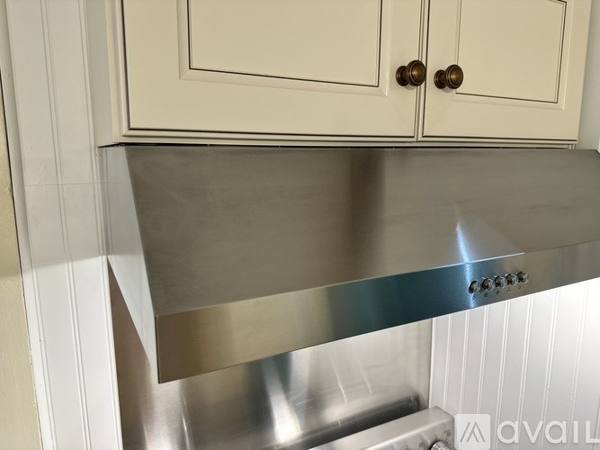 A stainless steel countertop with a white cabinet above it.