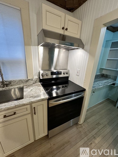 A kitchen with a stove top oven and a sink.