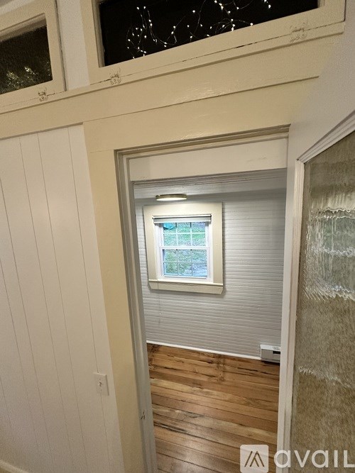 A room with a window and wooden floors.