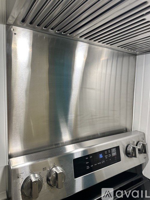 A stainless steel oven with a digital display and control knobs.