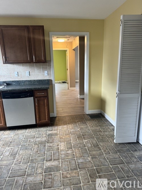 A kitchen with a dishwasher and a refrigerator.