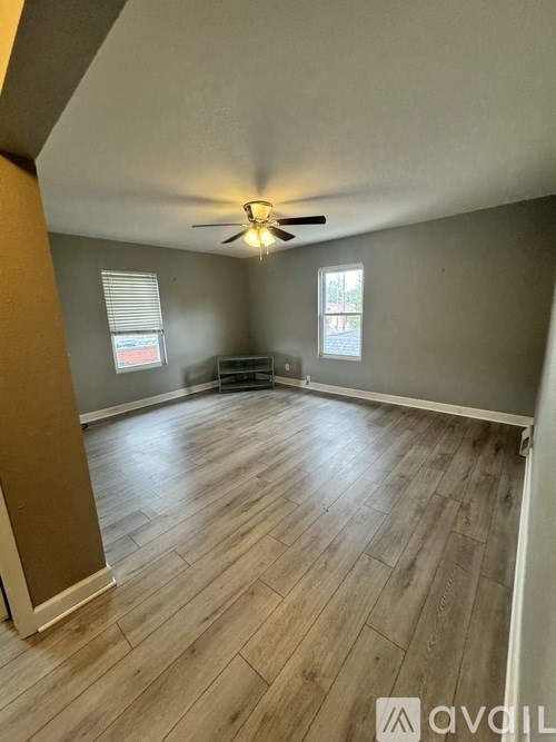 A room with wooden flooring and a ceiling fan.
