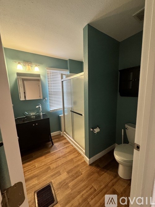 A bathroom with a toilet, sink, and mirror.