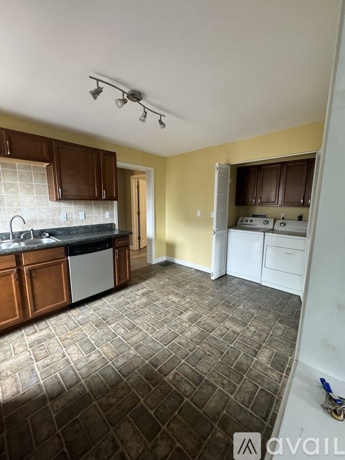 A kitchen with brown cabinets and a tiled floor.