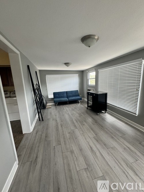 A living room with a grey floor and a blue sofa.