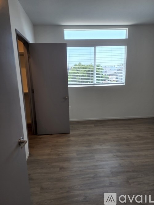 A room with a grey door and a window with blinds.