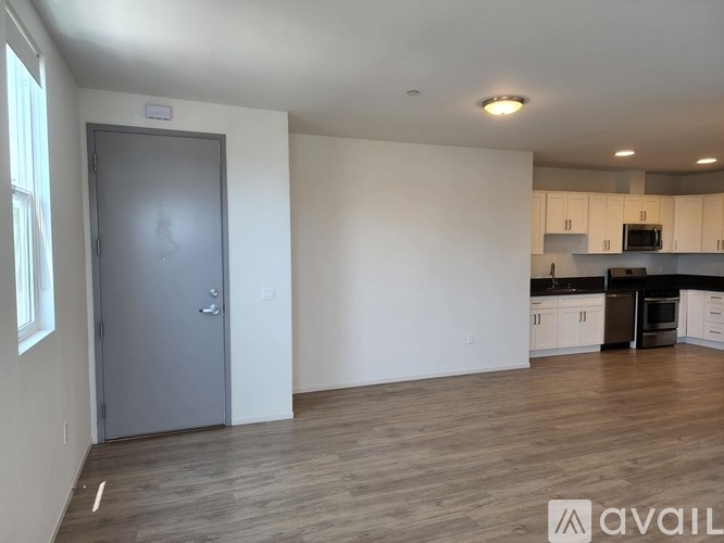 A room with a grey door and wooden flooring.
