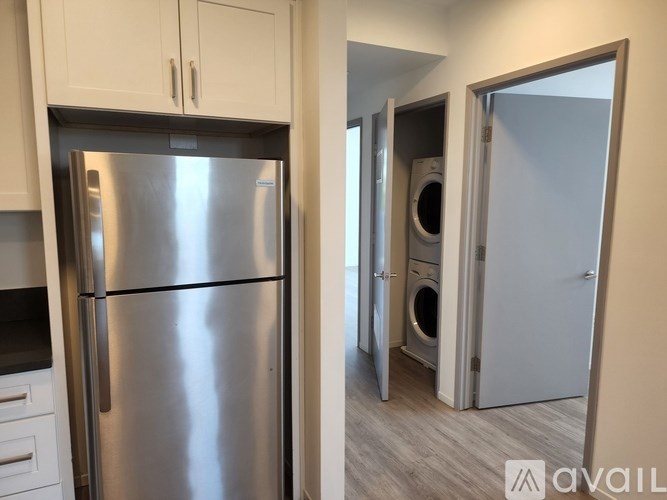 A stainless steel refrigerator in a kitchen with white cabinets.