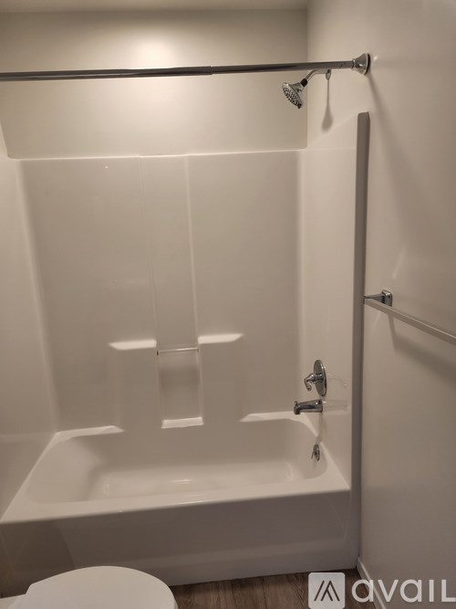 A white bathroom with a tub and toilet.