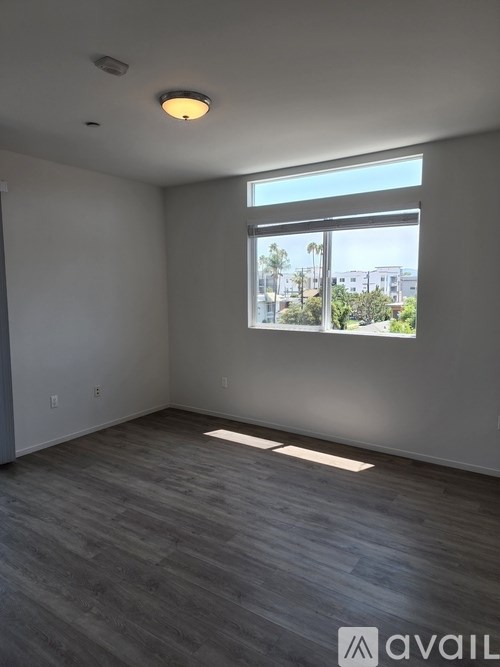 A room with a large window and a grey floor.