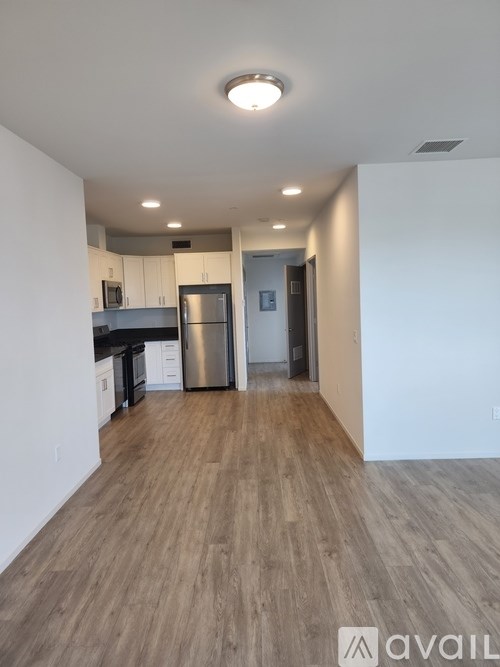 A kitchen with a refrigerator, cabinets, and a countertop.
