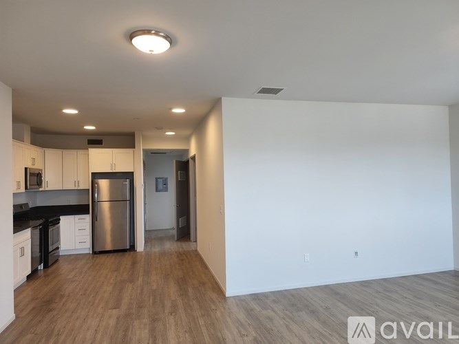 A kitchen with white cabinets and a stainless steel refrigerator.