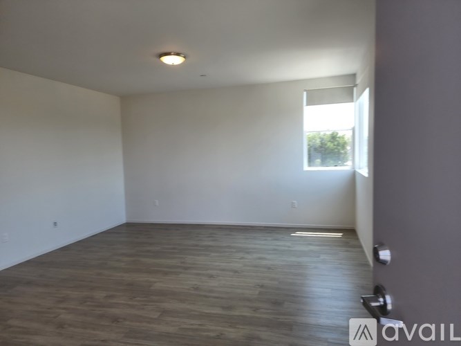 Empty room with wooden floor and white walls.
