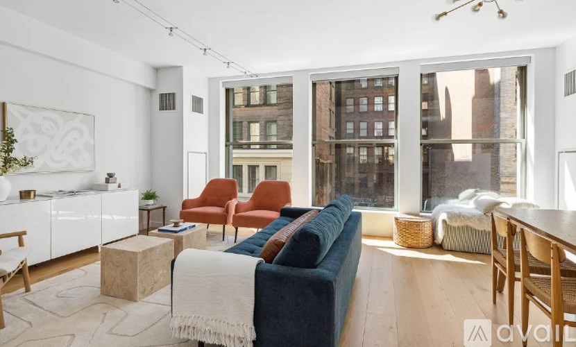 A living room with a blue couch and a large window.