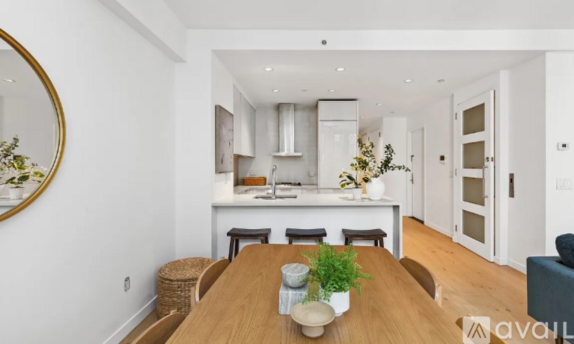 A modern kitchen with a wooden dining table and chairs.