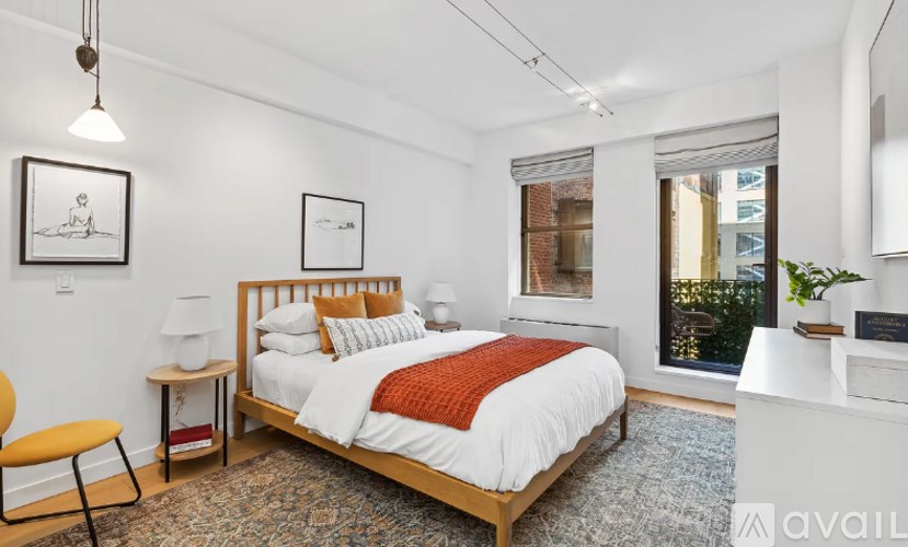 A bedroom with a large bed and a chair.