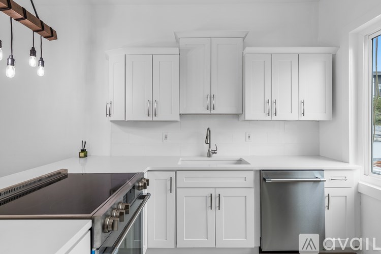 A kitchen with white cabinets and a stainless steel dishwasher.