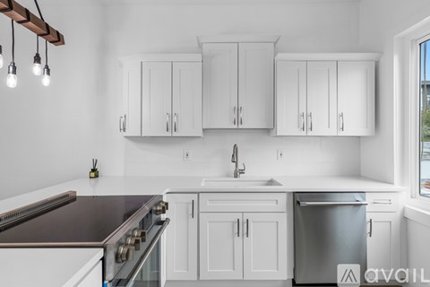 A kitchen with white cabinets and a stainless steel dishwasher.
