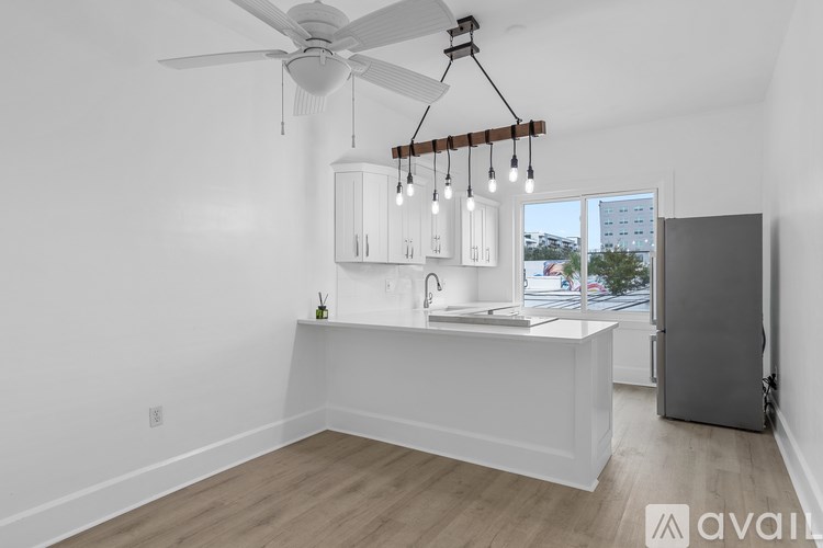 A kitchen with a white counter and a ceiling fan.