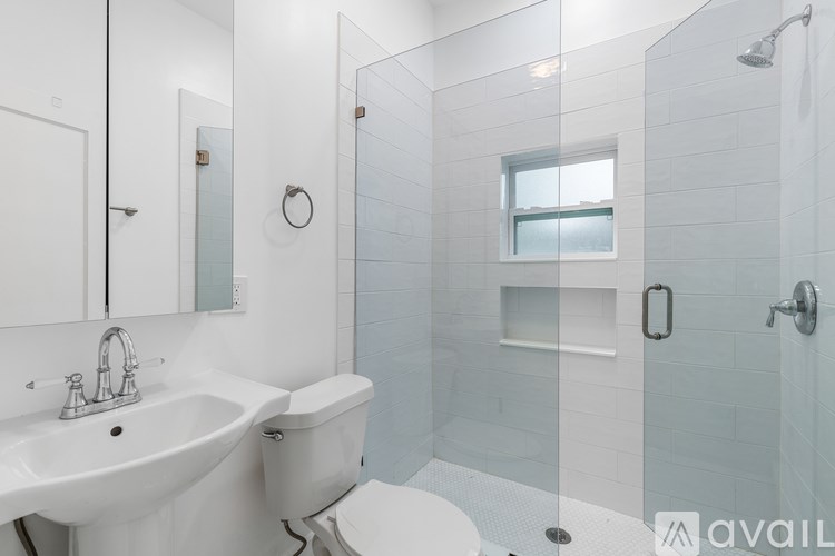 A white bathroom with a glass shower stall.