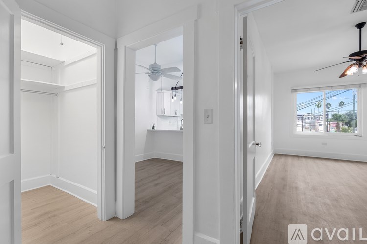 A spacious room with a ceiling fan and a view of the city.